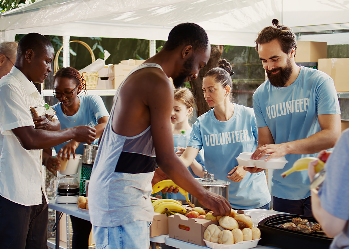 Volunteers serving food at an outdoor community event.