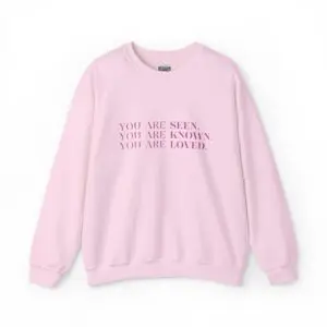 Pink sweatshirt with motivational text in black.