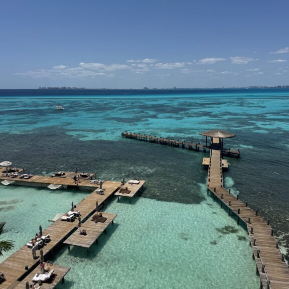Aerial view of a clear turquoise lagoon with piers extending into the water.
