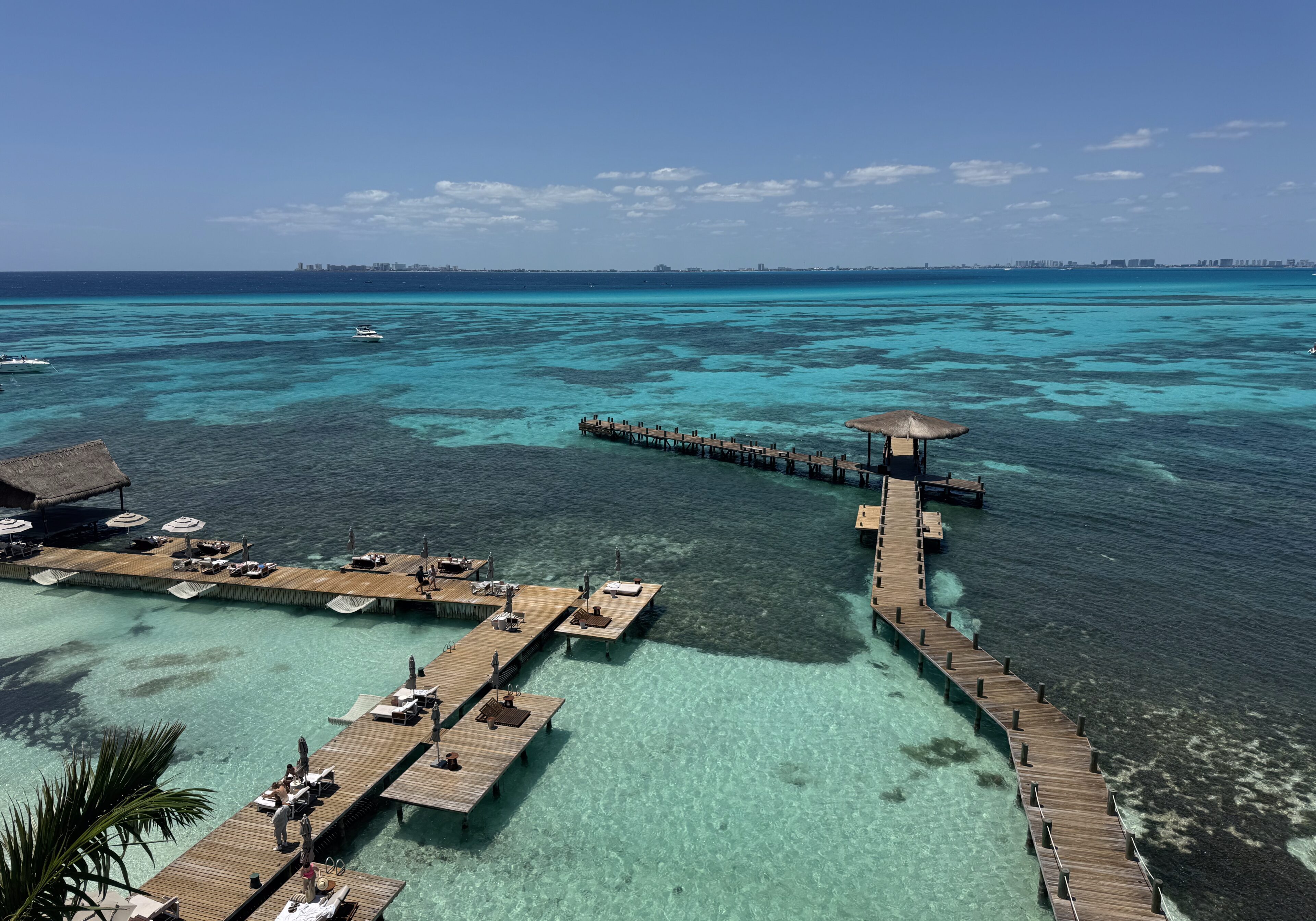 Aerial view of a clear turquoise lagoon with piers extending into the water.