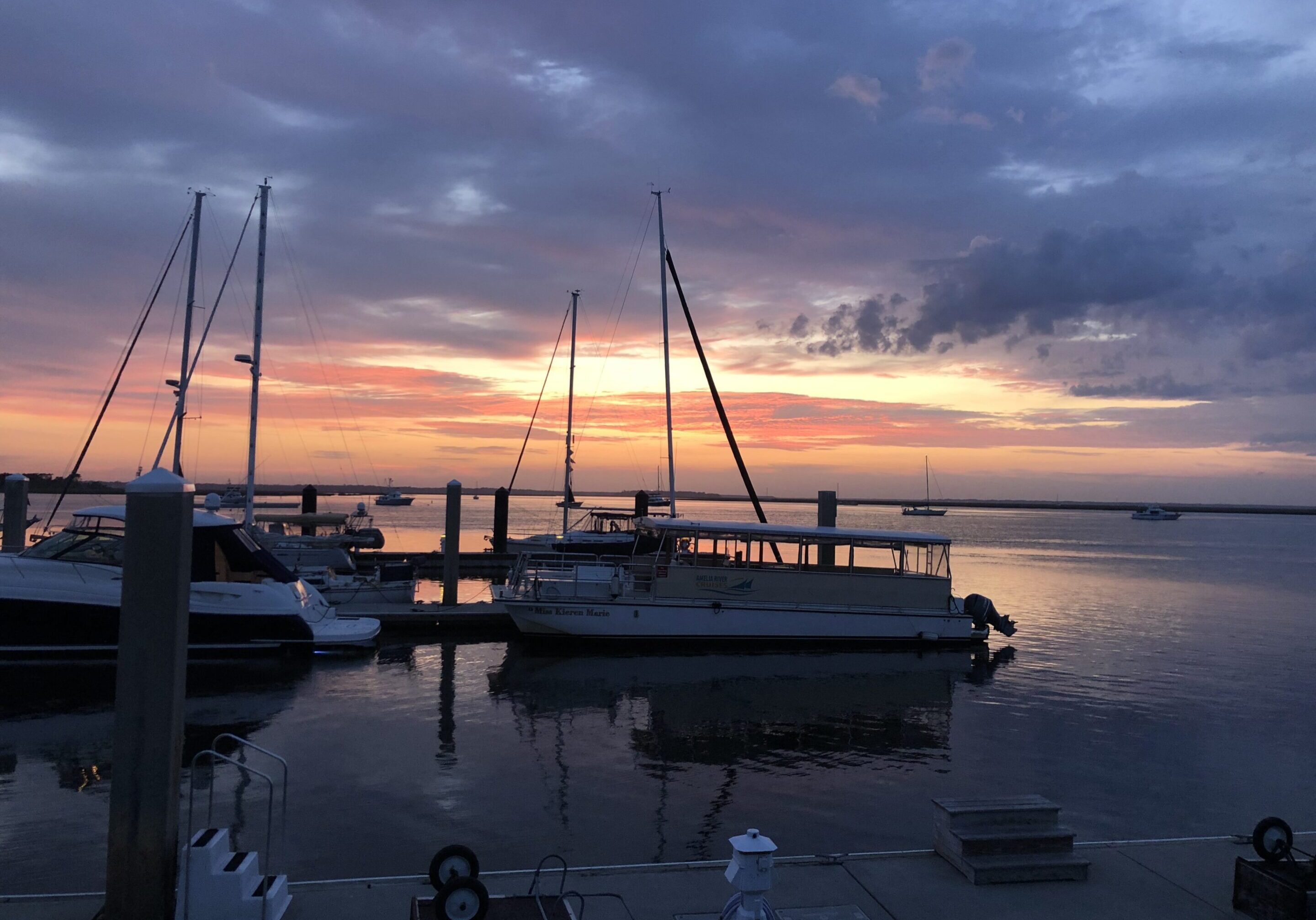 Boats docked at marina during sunset