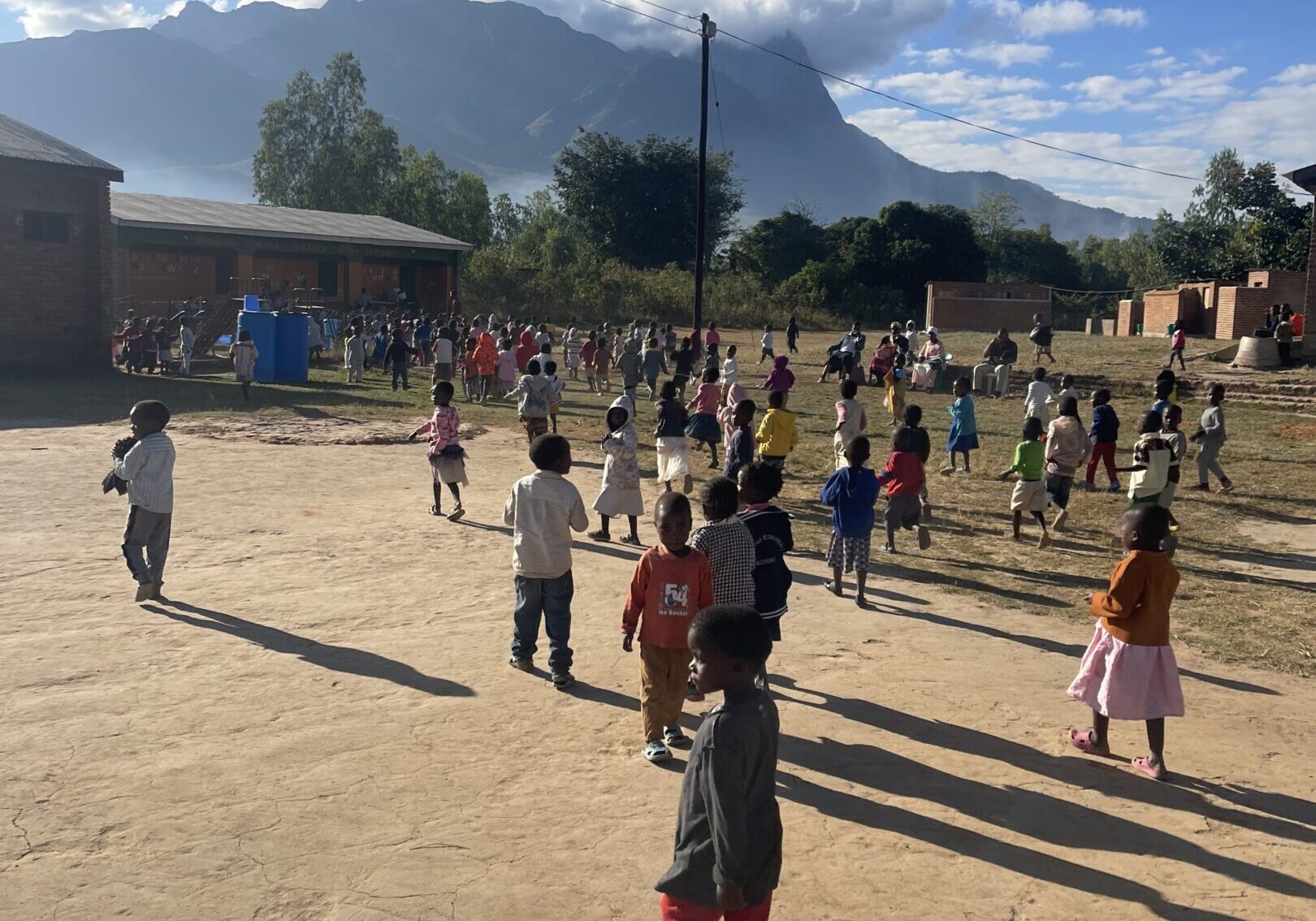 Children playing outdoors on a sunny day in a schoolyard.